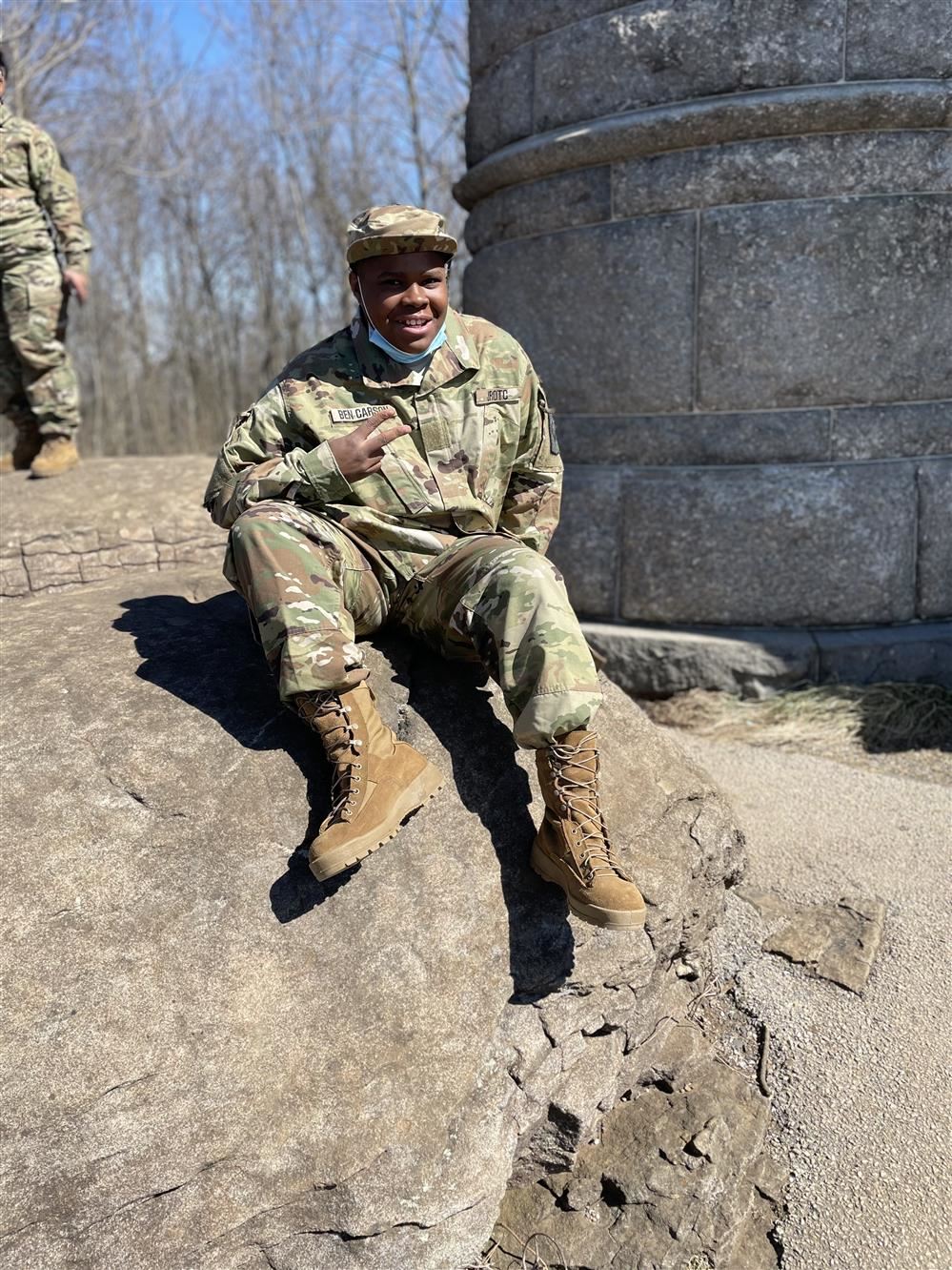  student in uniform on rock 